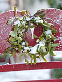 Wreath of Viscum album (Mistletoe) tied to red chair back