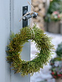 Simple wreath of Thuja (tree of life) hung on door handle