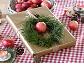 Natürliche Geschenkverpackung dekoriert mit Kranz aus Pinus