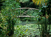 Brücke aus Holz und Bambusstäben über einen Teich