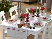 Weihnachtliche Tischdeko mit roten Kugel-Gestecken