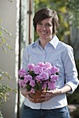 Woman with Rhododendron simsii (indoor azalea) in clay pot