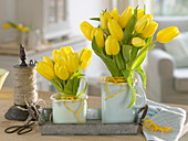 Standing bouquets of Tulipa 'Strong Gold' (tulips) in enamelled pots