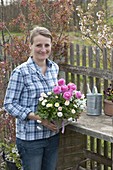 Woman holding basket box with Ranunculus (ranunculus), Bellis