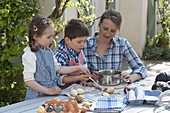 Woman with children dyeing eggs