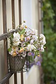 Put bouquet of roses in hanging pot on trellis
