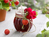 Glas mit Erdbeer-Marmelade, zum verschenken dekoriert