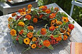 Orange-red wreath with Zinnia (Zinnias), Clematis vines, Sorbus