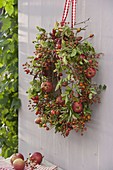 Wreath of pink (rosehips) on bark blank, decorated with apples
