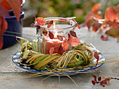 Lantern in a wreath of grasses, decorated with autumn leaves