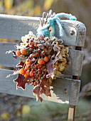 Gefrorener Herbststrauß mit Malus (Zieräpfeln), Rosa (Hagebutten),