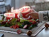 Natural Advent wreath with candle jars, moss, branches of holly