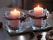 Pink candles in glasses with wreaths of Calluna (broom heather)