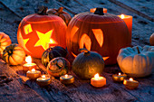 Halloween: STILL LIFE On WOODEN TABLE at NIGHT with CANDLES, PUMPKINS, GOURDS AND SQUASHES