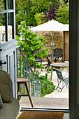 Designer: ANNE FOWLER - VIEW OUT of THE BACK of THE HOUSE DOWN STONE STEPS TO THE Patio AND Garden BELOW