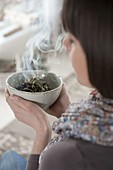 Woman smoking herbs in herb bowl