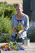 Tying blue-orange summer flower bouquet