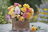 Bouquet of mixed pinks (roses) from the garden in paper bag