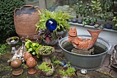 Terracotta fish as water feature in zinc tub