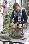 Woman decorating Advent wreath with natural materials