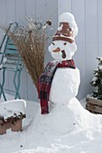 Schneemann mit Tontopf als Hut, Schal, Kohlstrunk als Pfeife, Karotte als Nase