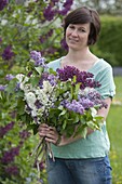 Woman with freshly cut Syringa (Lilac) for scented bouquet