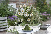 Standing bouquet of Leucanthemum vulgare (daisies) and meadow grasses