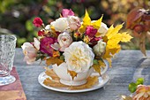 Autumn mini bouquet of different pinks (roses) and leaves