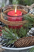 Lantern with red candle in a natural wreath made of Pinus (pine) twigs