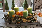 Mediterranean Advent wreath with olive branches, black dates, mandarins
