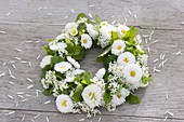 Tying a wreath of daisies and herbs