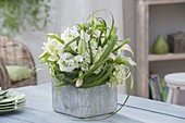 Green-white bouquet in gray concrete pot