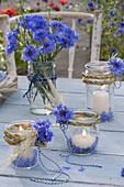 Rural table decoration with preserving jars as lanterns