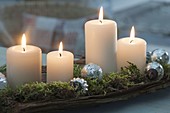 Simple Advent decoration with 4 candles on bark, decorated with moss
