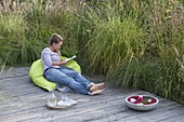 Holzterrasse mit Graeserbeet als Sichtschutz