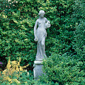 Statue in 'The Manor House' zwischen Gehölzen