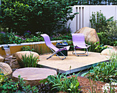 RSPB Garden, CHELSEA FLOWER Show 2002. Water Feature: RILL with WATERFALL SURROUNDED by Boulders, TERRACE with LILAC CHAIRS