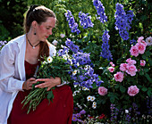 Frau mit Blumenstrauß aus Delphinium (Rittersporn) und Leucanthemum