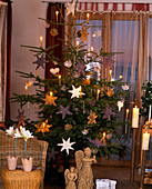 Nordmann fir decorated with natural decorative stars (lavender stars) and beeswax candles