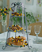 Etagere with croissant, biscuits and horned violet (Viola)