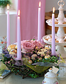 Eisenkorb mit Kerzen, Buchszweige, Rosenblüten, marmorierte