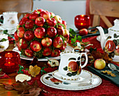 Table decoration with Malus (ornamental apples) on wooden sticks and stuck in plugging compound