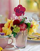 Spring table decoration: name plate around glass vase