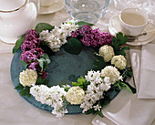 Plate wreath of flowers of lilac and viburnum