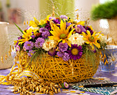 Sisal basket with late summer arrangement of asters and sun hat