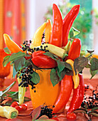 Paprika und Holunderbeeren zu dekorativem Strauß gesteckt