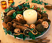 Plate with advent decoration made of cones, oranges, ivy and cinnamon sticks