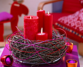 Kranz aus Larix (Lärchenzweigen) mit roten Kerzen und buntem Peddigrohr
