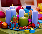 Colorful candles on plate with Christmas decoration
