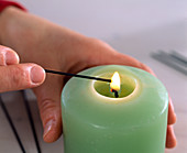 Kerzen auf Adventskranz befestigen (1/4), Draht über Kerze erhitzen